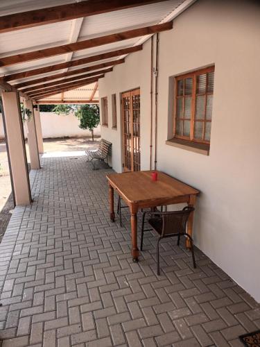 a patio with a wooden table and a chair at Featherhouse in Colesberg