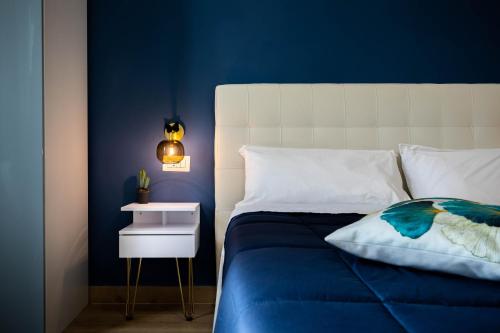 Dormitorio azul con cama y mesita de noche en Affori House, en Milán