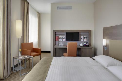 a hotel room with a bed and a table and chairs at IntercityHotel Leipzig in Leipzig