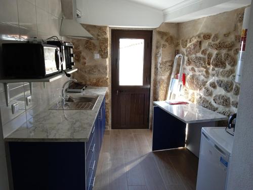 uma cozinha com um lavatório e um micro-ondas em Isabel de Gouveia em Belmonte