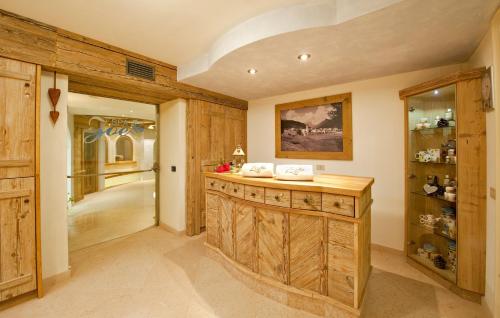 a kitchen with wooden walls and a counter in a room at Hotel Des Alpes in Soraga