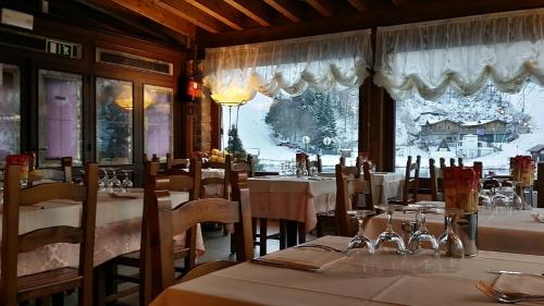 a restaurant with tables and chairs with snow on the windows at Albergo Diana in Cerreto Laghi