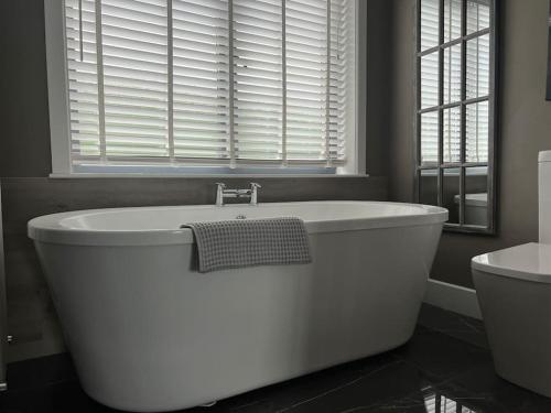 a white bath tub in a bathroom with a window at Contemporary Townhouse Stunning lakeside location in Belturbet