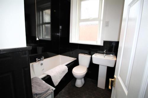 a bathroom with a white toilet and a sink at Large Period Property - Beautifully Refurbished in Newcastle upon Tyne