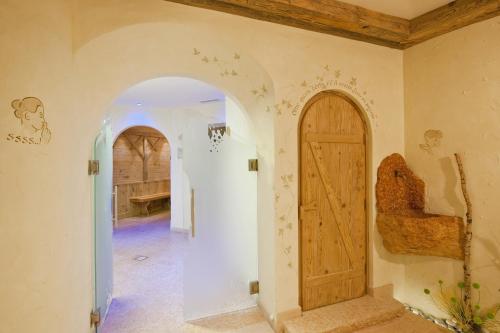 a hallway with an archway and a door at Hotel Des Alpes in Soraga
