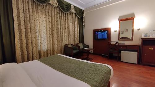 a hotel room with a bed and a desk at Hotel Sepal in Bathinda