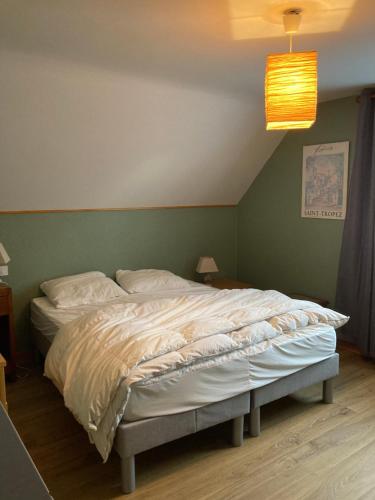Murat-le-QuaireにあるMaison Le Pré Grandの緑の壁のベッドルームに大型ベッド1台が備わります。