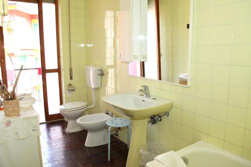 bagno con lavandino, servizi igienici e specchio di Casa Manu Apartments a Monterosso al Mare