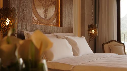 a bedroom with a bed with white sheets and pillows at Marti Hemithea Hotel in Orhaniye