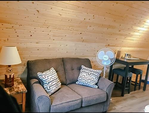 ein Wohnzimmer mit einem Sofa und einem Tisch mit einem Ventilator in der Unterkunft Hillside Cottages in Bay Roberts