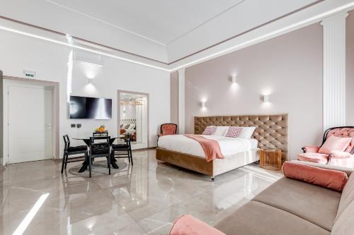 a bedroom with a bed and a table and a couch at UnoSeiTre - Luxury Apartment & Suite in Rome