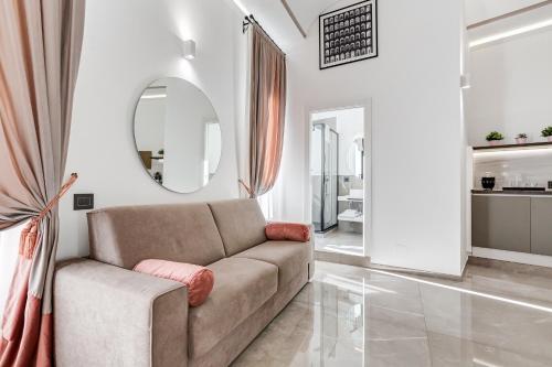 uma sala de estar com um sofá e um espelho em UnoSeiTre - Luxury Apartment & Suite em Roma