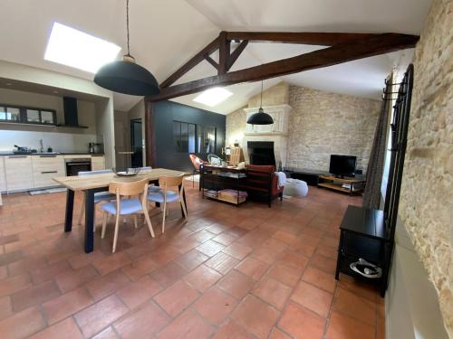 une cuisine et un salon avec une table et des chaises dans l'établissement L’océan 20, à Queyrac