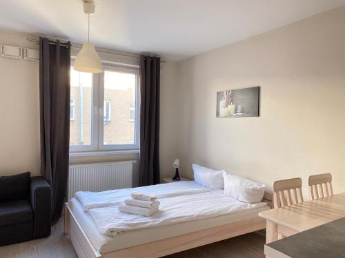 a bedroom with a bed and a table and a window at Residence Aparthotel in Szczecin