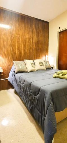 een slaapkamer met een groot bed en een houten muur bij Excelente apartamento en Plaza Independencia. in Montevideo