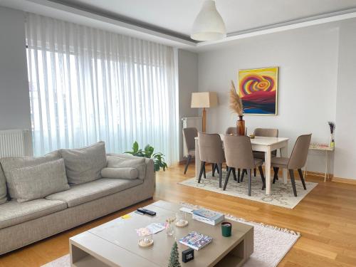 een woonkamer met een bank en een tafel bij NEW BUILDING Lovely Modern Apt with 90mbs fiber internet 5min walking to Bagdat Street in Istanbul