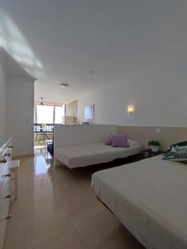 1 dormitorio con 2 camas y sala de estar en Apartamento primera línea - Playa Patalavaca, en Patalavaca