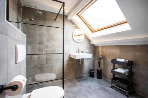 a bathroom with a shower toilet and a sink at Hotel Neptunus in Egmond aan Zee