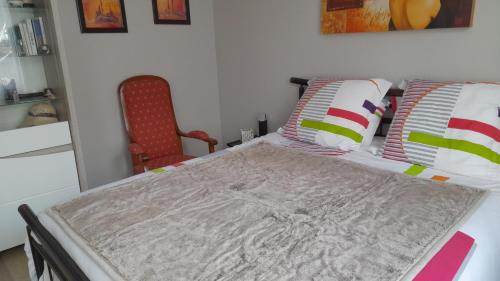 Ce lit se trouve dans un dortoir doté d'une chaise rouge. dans l'établissement La terrasse, à Poitiers