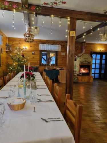 a long table in a restaurant with a christmas tree at Maciejówka Borki 33 in Borki