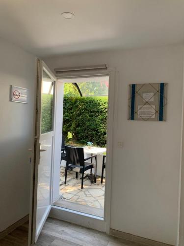 an open door to a patio with a table and chairs at HENDAYE PLAGE (850m) APPARTEMENT 1-4 PERSONNES in Hendaye