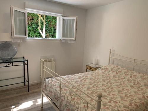a white bedroom with a bed and a window at HENDAYE PLAGE (850m) APPARTEMENT 1-4 PERSONNES in Hendaye