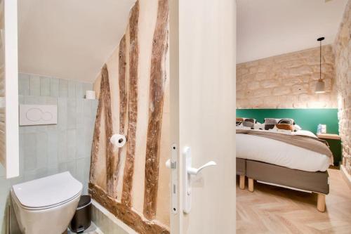 ein Bad mit einem Bett und einem WC in einem Zimmer in der Unterkunft Magnifique studio au coeur de Montmartre in Paris