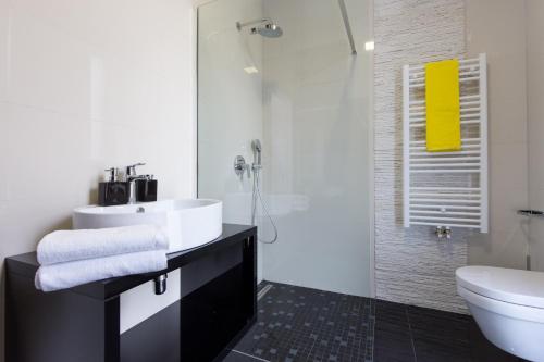 a bathroom with a sink and a shower and a toilet at Villa Superior Two in Crikvenica