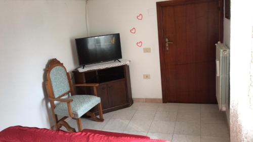 een woonkamer met een televisie en een stoel bij CASA VACANZE ROSA BLU in Giffoni Valle Piana