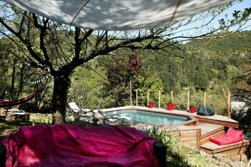 - une piscine dans une cour avec un arbre dans l'établissement Le Mas Des Pots Rouges, à Cros
