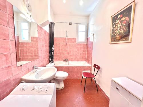 une salle de bains rose avec lavabo et toilettes. dans l'établissement ApartHotel Riviera - E Vieille Ville Quartier du Port - Place du Pin - Très Grand Appartement de 5p - Lumineux et à 50m de la Mer - DUPLEX ANTOINE GAUTIER, à Nice