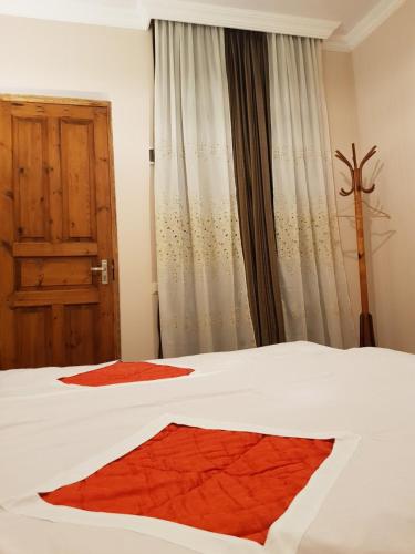 1 dormitorio con 1 cama blanca y ventana en Tkhibuli geust house en Tqibuli