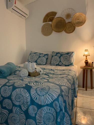 een slaapkamer met een bed met een blauwe en witte deken bij Pousada Sette Mares in Fernando de Noronha
