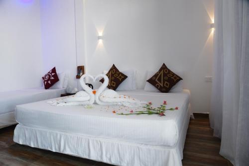 a bedroom with two beds with a stuffed animal on it at Dinuda Resort in Kalpitiya