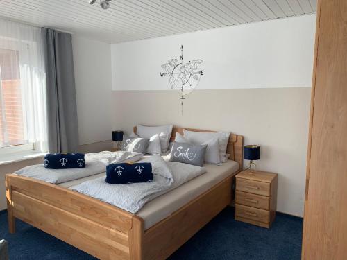 a bedroom with a bed with blue pillows on it at Hotel Meerblick garni in Neuharlingersiel