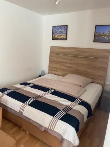 a bedroom with a bed with a wooden headboard at Appartement Leon in Düsseldorf