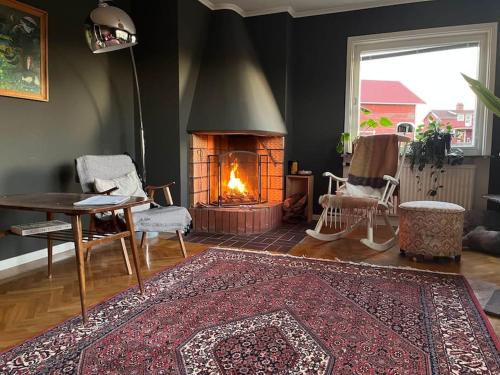a living room with a fireplace and a table and a rug at Homestay in picturesque village in Nusnäs