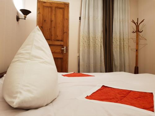1 dormitorio con cama blanca y almohada en Tkhibuli geust house en Tqibuli