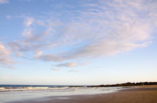 a beach with a cloudy sky and the ocean at Vv - San Agustín Seaview Apartment in San Agustin
