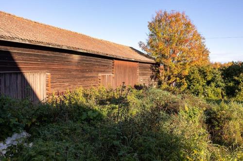 an old wooden building with a lot of weeds around it at Homestay in picturesque village in Nusnäs