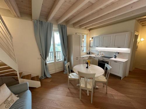 eine Küche mit einem Tisch und einem Waschbecken sowie einem Tisch und Stühlen in der Unterkunft Green Living Apartment in Pozzolengo