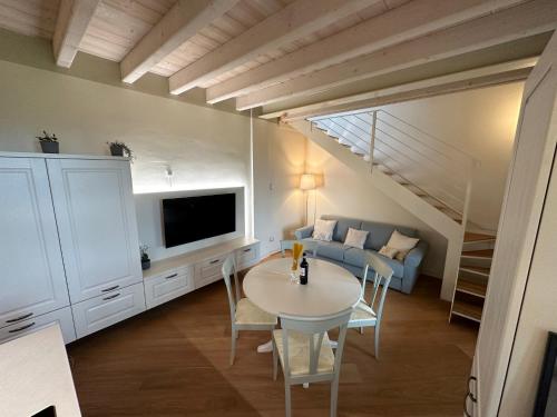 uma sala de estar com uma mesa e um sofá em Green Living Apartment em Pozzolengo