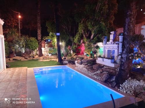 a swimming pool in a yard at night at וילה מונטאנו עם בריכה מחוממת וג'קוזי במרכז העיר - Villa Montano with a heated pool and jacuzzi in the city center in Rishon LeẔiyyon