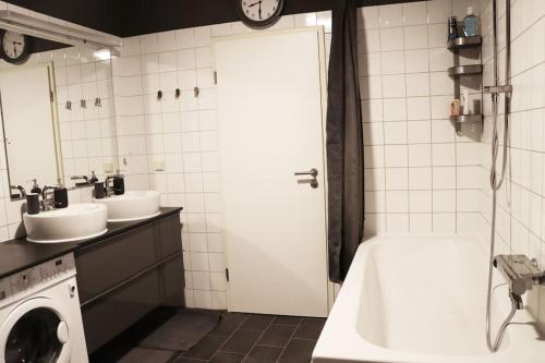 uma casa de banho com uma banheira, um lavatório e uma máquina de lavar roupa em gemütliche & ruhige Unterkunft em Erftstadt