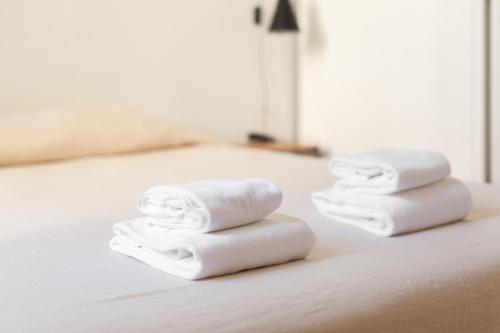 two towels sitting on top of a bed at Alameda Suites - River Guest House in Porto