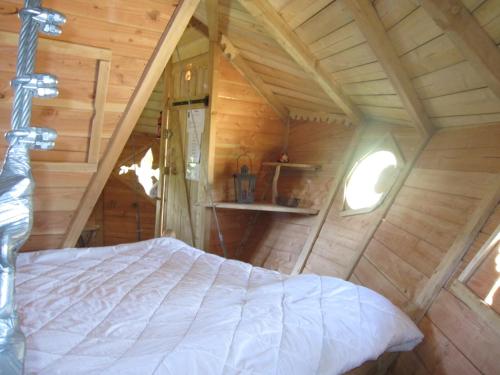- une chambre avec un lit dans une cabane dans les arbres dans l'établissement Parc de la Belle, à Magne