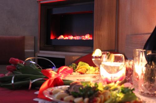 格涅茲諾的住宿－Klinkierowa Komnata，餐桌,餐桌上放着一盘食物,壁炉
