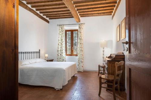 um quarto com uma cama, uma secretária e uma janela em Poggio Vitignano Charming Cottage With Pool and Parking em Pianella