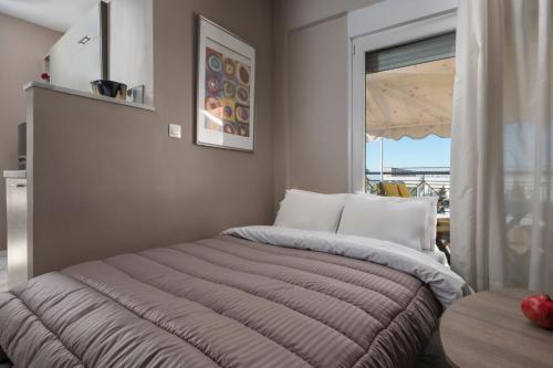 Bett in einem Zimmer mit Fenster in der Unterkunft Egnatia flat 2 in Thessaloniki