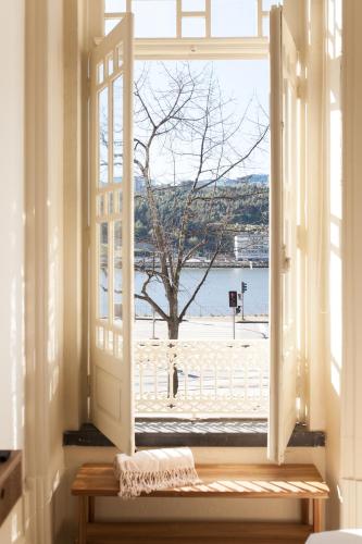 an open window with a view of a beach at VIVA Alameda Suites - River Guest House in Porto